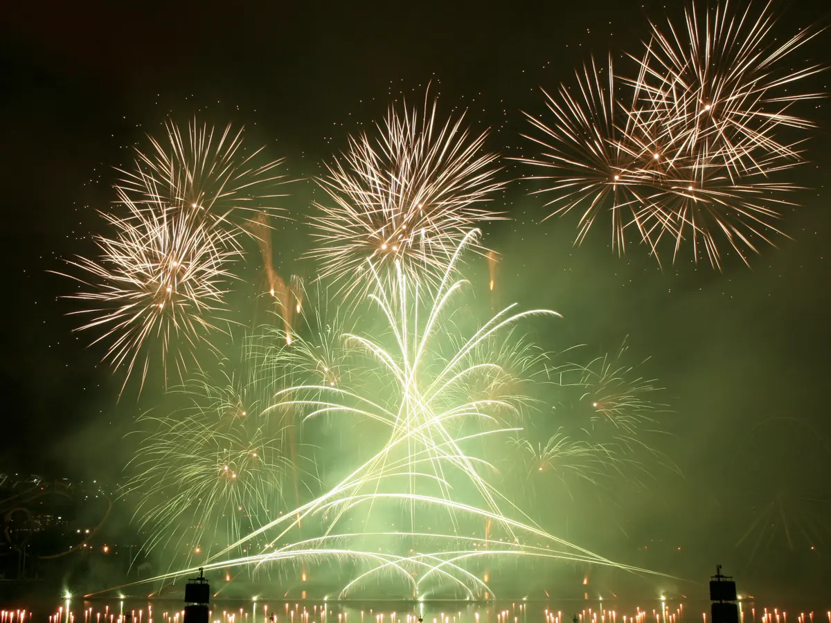Feu d'artifice vert et or sur plan d'eau